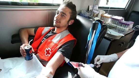 Un joven dona sangre en la colecta de cruz roja.