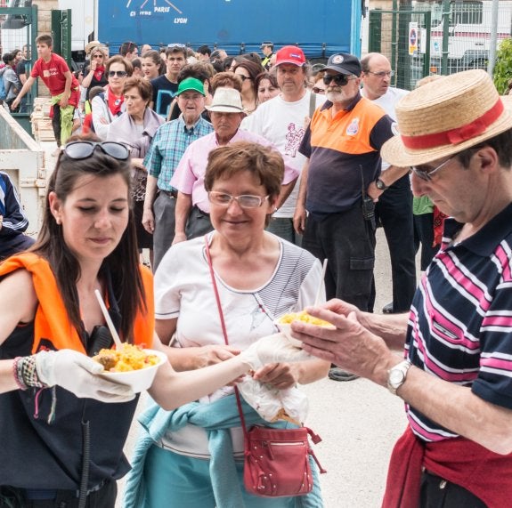 Una voluntaria de Protección Civil reparte la paella, cuya preparación organizó el Ayuntamiento. :: albo