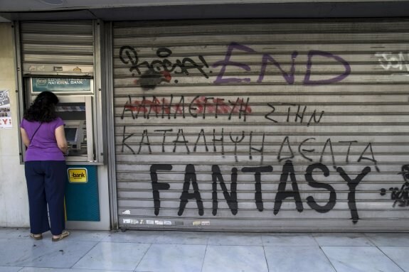 Una mujer saca dinero en un cajero automático durante la jornada electoral en Grecia. :: marko djurica / reuters