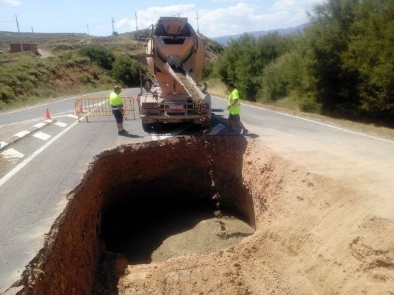 Trabajos de reparación en el socavón de la LR-281, casi a la entrada del municipio de Quel. :: m.f.