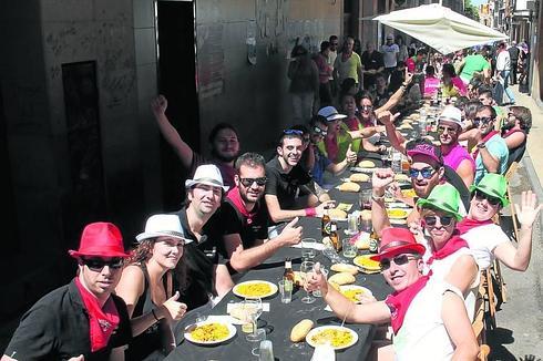 Plato compartido. Unos 500 jóvenes participaron en la sexta edición de la comida popular, que llenó la calle San Antón. 