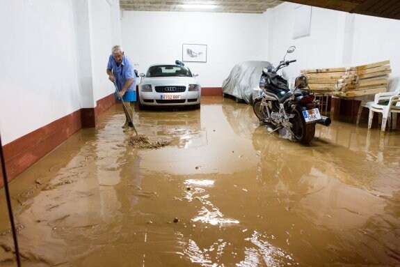 Un vecino limpiando la bajera de su vivienda durante la noche del lunes en San Asensio. :: s. tercero
