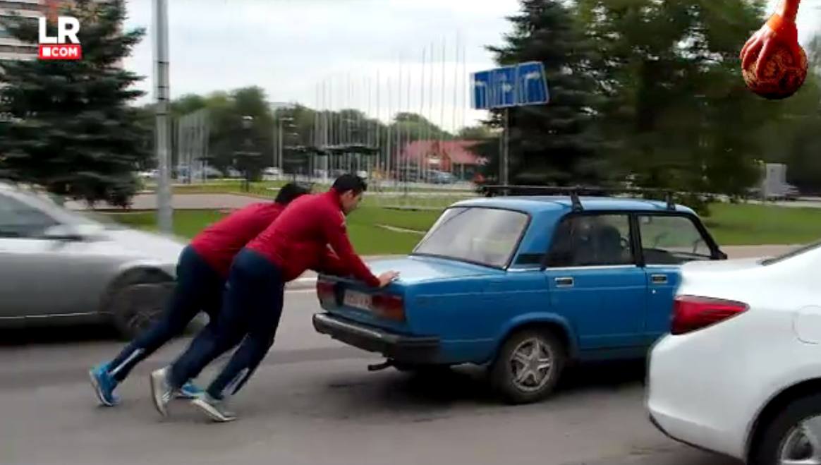 Un par de jugadores del Naturhouse ayudan a un conductor a arrancar el coche. 