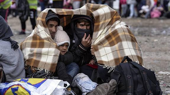 Una familia de refugiados se protege del frío en su peregrinaje por centroeuropa. 