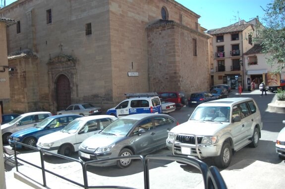 Los vehículos aparcados en la plaza de la Cruz rodean la histórica iglesia y limitan el paso de peatones. :: p.j.p.