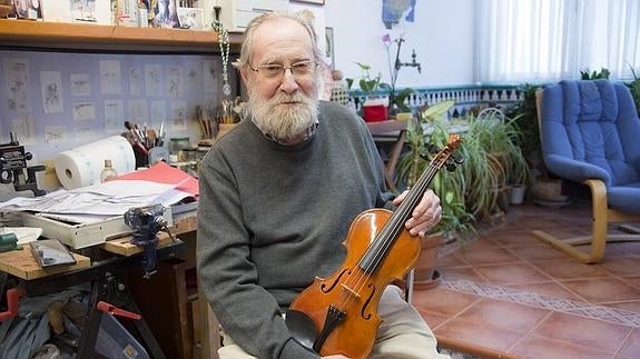 Julio Sabrás posa con su violín en el estudio de su casa. 