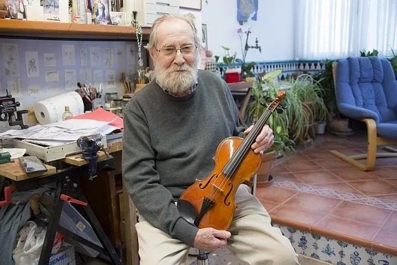 Julio Sabrás posa con su violín en el estudio de su casa. 