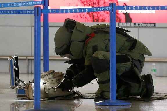 Un artificiero de la Policía examina un equipaje en el aeropuerto de Pudong, en Shanghái. :: Aly Song/ reuters