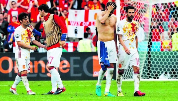 Duro golpe. San José trata de animar a Silva (a la izquierda), mientras Piqué y Cesc abandonan el césped de Saint-Denis con gesto de desolación. :: efe