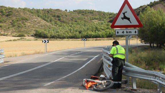 Un agente toma nota de los indicios del accidente junto a la moto destrozada por el impacto. 