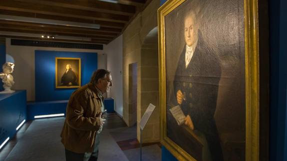 Una persona observa un cuadro en la exposición de Haro. 