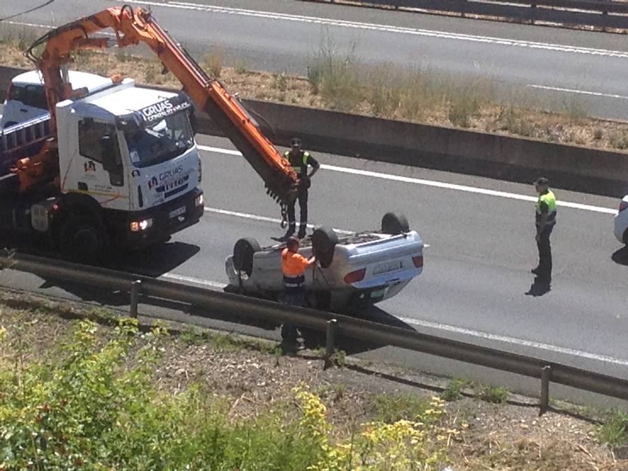 Un camión grúa trata de dar la vuelta al vehículo volcado. 