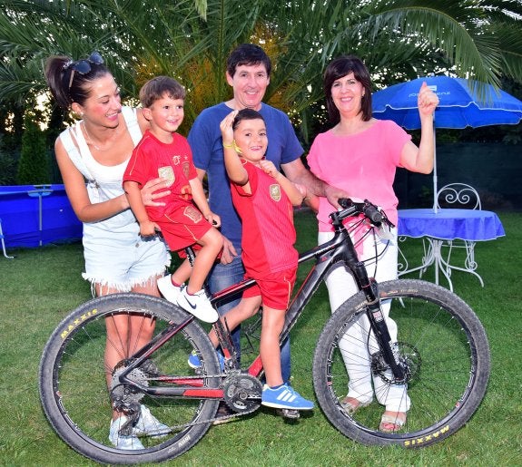 En pleno. Loli, Lucas, Carlos padre, Carlos Nieto y Encarna posan en el jardín de la casa familiar junto a una bicicleta del padre, otro apasionado de las bicis. :: miguel herreros