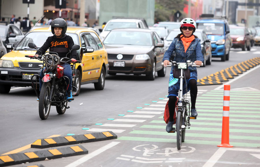 Una ciclista comparte tráfico en un carril bici de una ciudad. 