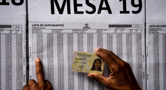 Una mujer comprueba su número de identificación antes de votar en el consulado de Colombia en Caracas, la capital venezolana. 