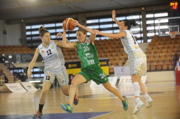 Cecilia Liñeira (26) penetra hacia la canasta riojana ante María España (12) y Nicole Romeo (14). :: El Correo