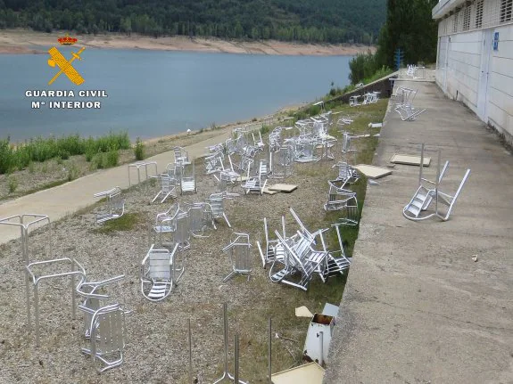 Las mesas y sillas de la terraza aparecieron destrozadas cerca del agua del pantano. :: guardia civil