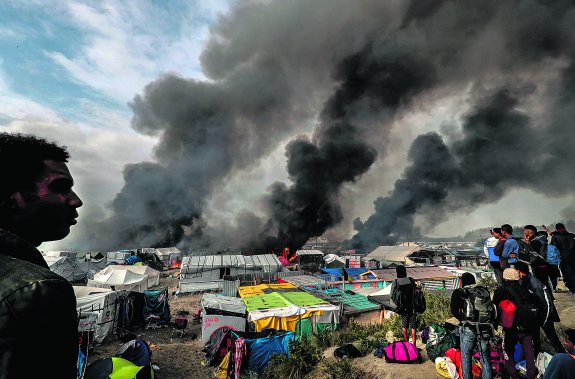 Negras columnas de humo ascienden al cielo de Calais desde los incendios provocados por los emigrantes en sus antiguas moradas. :: Philippe Wojazer / REUTERS