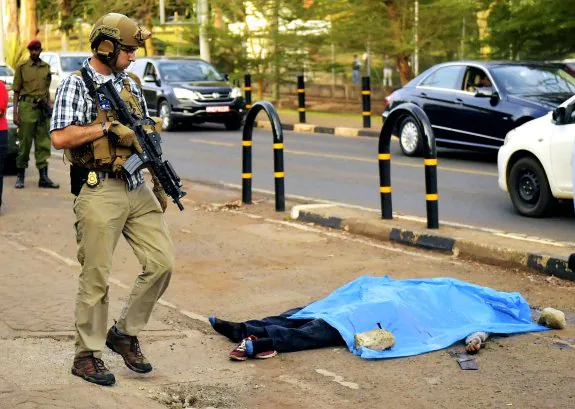Un Policía estadounidense, ante el cadáver de un ciudadano asesinado frente a la Embajada de EE UU en Nairobi (Kenia), el jueves. :: afp