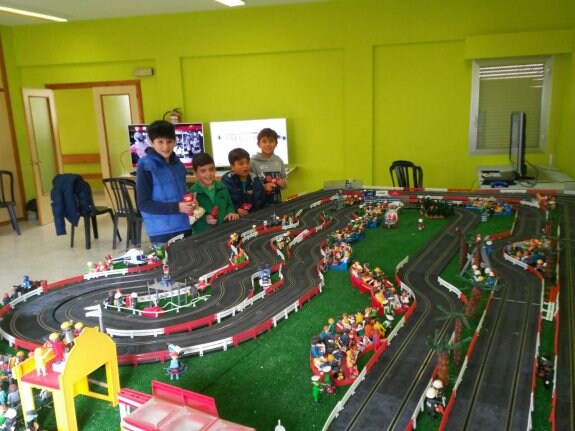 Varios niños juegan al scalextric en el Centro Joven. :: 