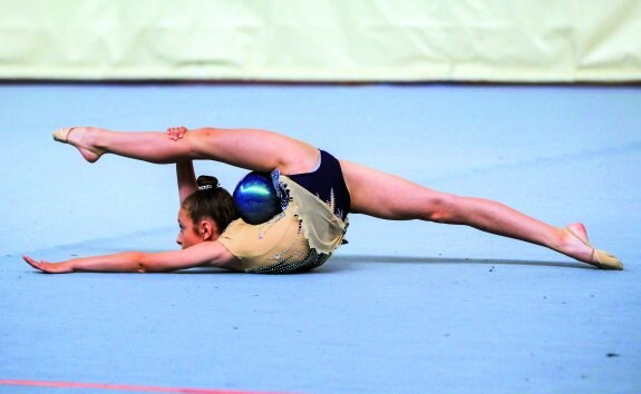 Una gimnasta realiza una coreografía sobre el tapiz.  :: F.Díaz