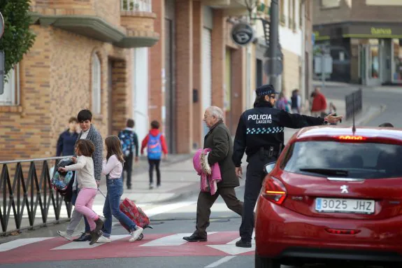 Un agente de la Policía Local de Lardero ordena el tráfico a la salida de un colegio. :: 