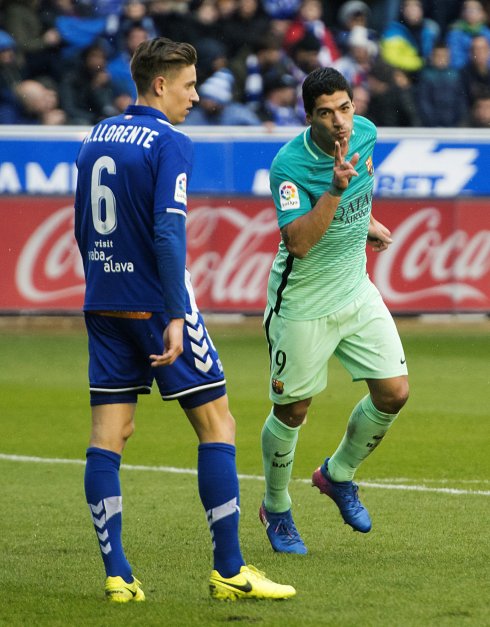 Luis Suárez celebra ante Marcos Llorente uno de sus goles de ayer en Mendizorroza. :: efe