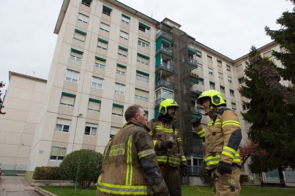 Tres bomberos comentan la incidencia tras sofocar las llamas en la calle Eliseo Pinedo, 8. :: 