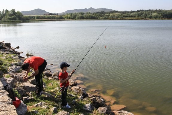 Un joven pescador lanza  su caña en La Grajera.  