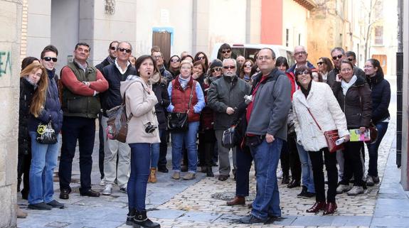 Un grupo de turistas observan un punto de interés del casco viejo de  Logroño. 