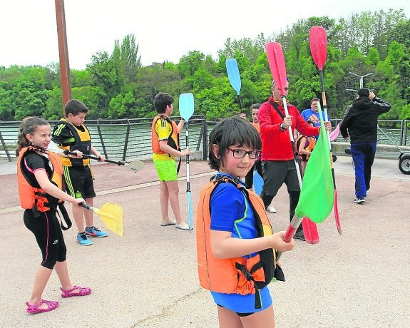 Unos escolares son instruidos por los monitores antes de coger las piraguas. :: F.D.
