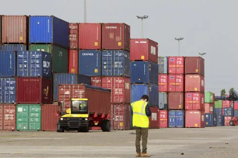 Un estibador transporta un contenedor de mercancías en el puerto de Sevilla. :: raúl doblado
