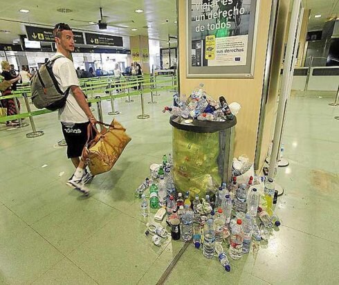 Un pasajero pasa junto a una montaña de basura en el aeropuerto de Ibiza. :: r. c.