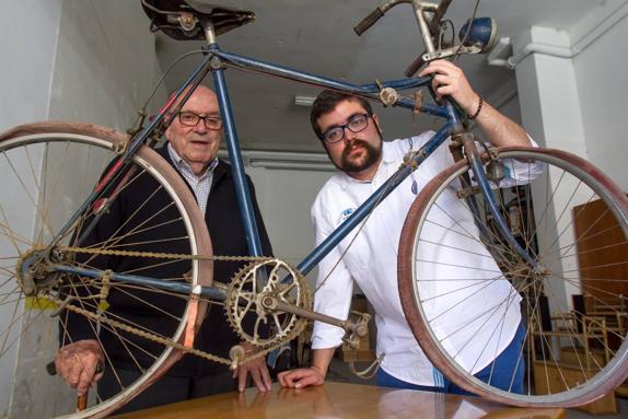 Javier Adarraga (hijo) y Javier Adarraga (biznieto) posan con la bicicleta de plato ovalado de su padre y bisabuelo, respectivamente. 