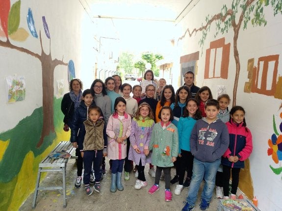 Los niños, tras acabar el mural posan con las autoridades. :: 