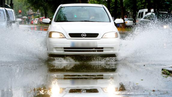Un vehículo transita por un charco después de una tormenta. 