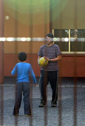 Un educador juega con un niño en el patio de la residencia Iregua de Logroño. ::                             J. MARÍN