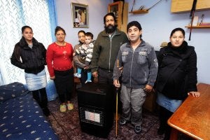 Calle Padre Marín. Enrique Jiménez posa en el salón de su vivienda junto a la estufa de gas; el frío aprieta y este padre de familia numerosa ha tapado las ventanas con plásticos y cartones. ::                             JUSTO RODRÍGUEZ