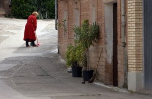 Cordovín se despereza sin reloj... Imagen de una vecina mientras barre la puerta de la calle. ::                              J. RODRÍGUEZ