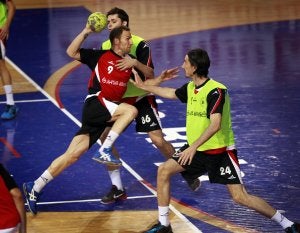 Sasha se lanza a portería entre el pivote Ales (86) y el extremo Curuvija durante un entrenamiento. ::                                                        JUSTO RODRÍGUEZ