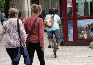 Una ciclista, por el medio de la acera en una céntrica calle de Logroño./MIGUEL HERREROS