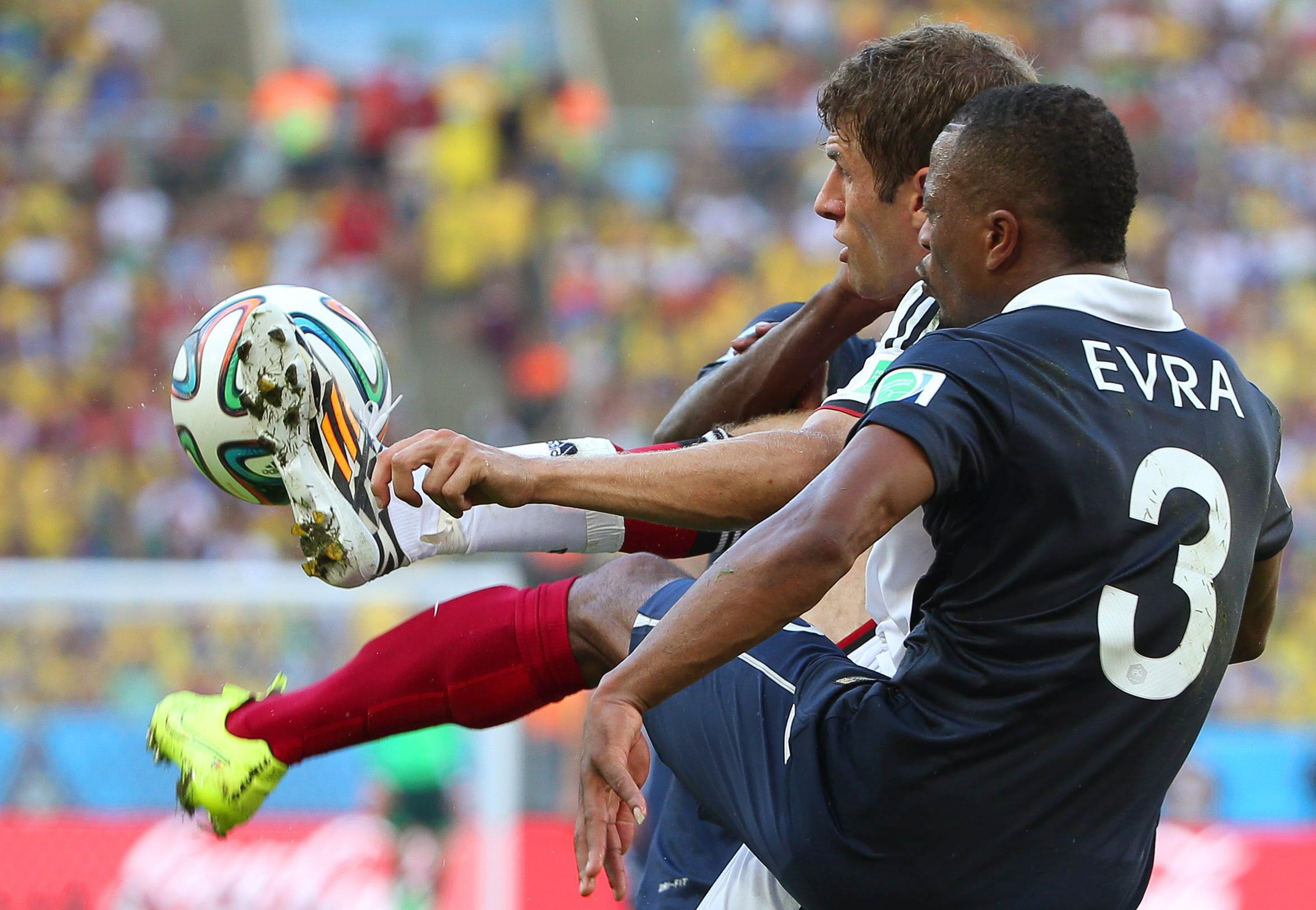 Evra (d) y Müller pelean por un balón.