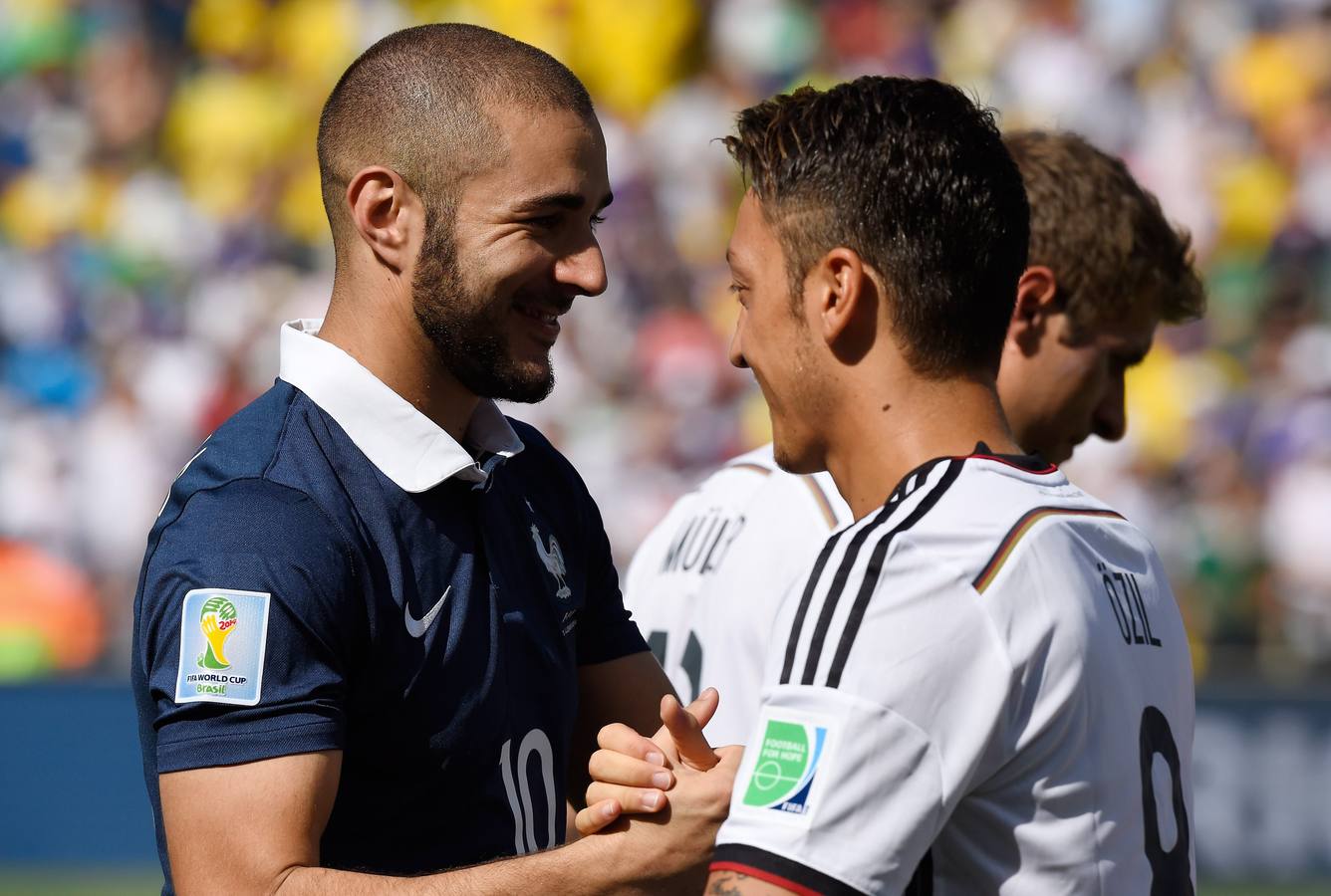 Benzema y Özil, excompañeros en el Madrid, se saludan antes del partido.