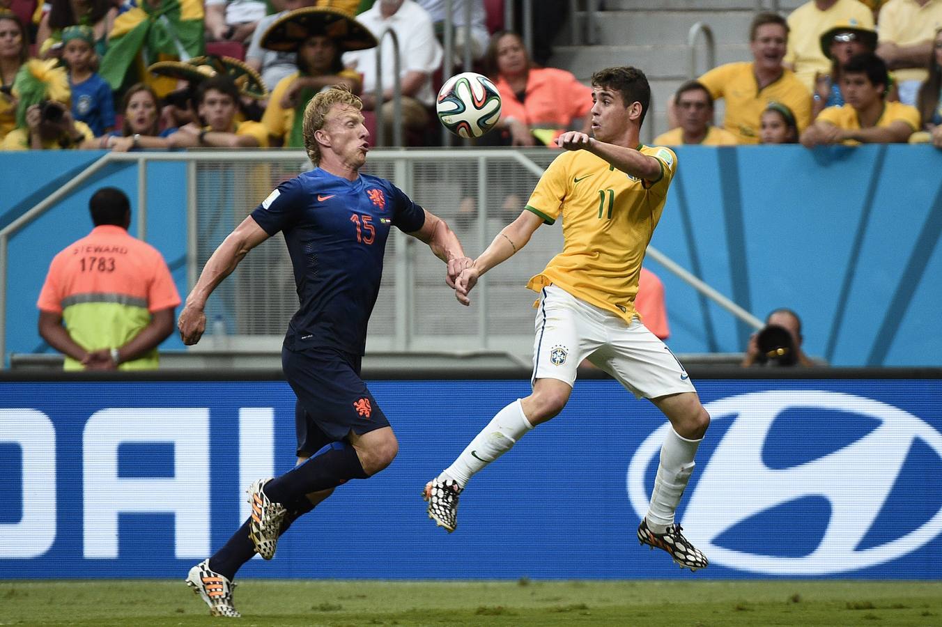 Kuyt y Oscar pelean por el balón.