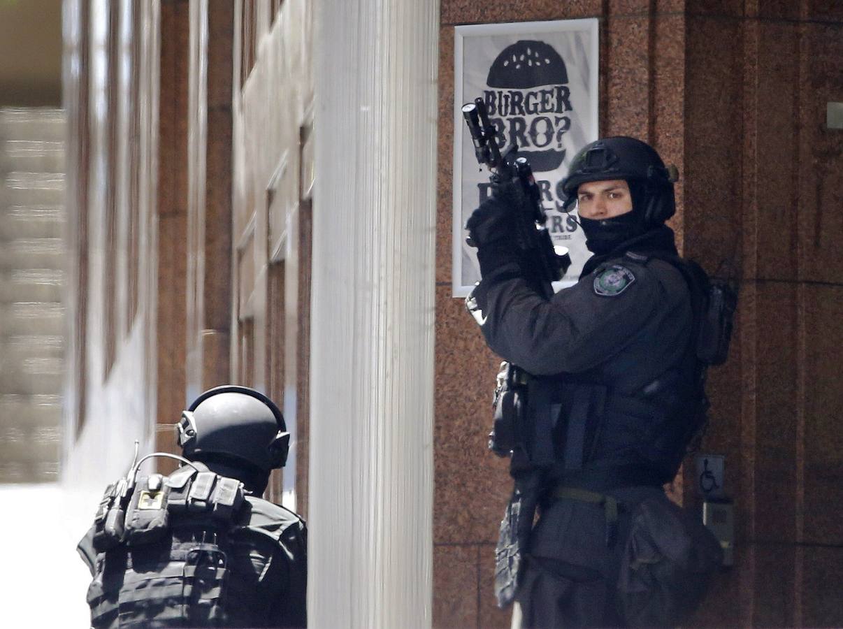 Agentes especiales de la policía australiana toman posiciones antes de asaltar la cafetería donde el secuestrador tiene a los rehenes