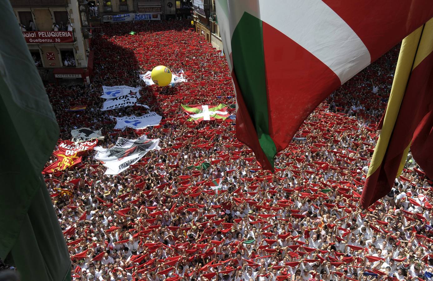 Desde el balcón del Ayuntamiento se aprecia la gran cantidad de asistentes que se han dado cita para celebrar el chupinazo en la Plaza Consistorial y que alzan sus 'pañuelicos'.