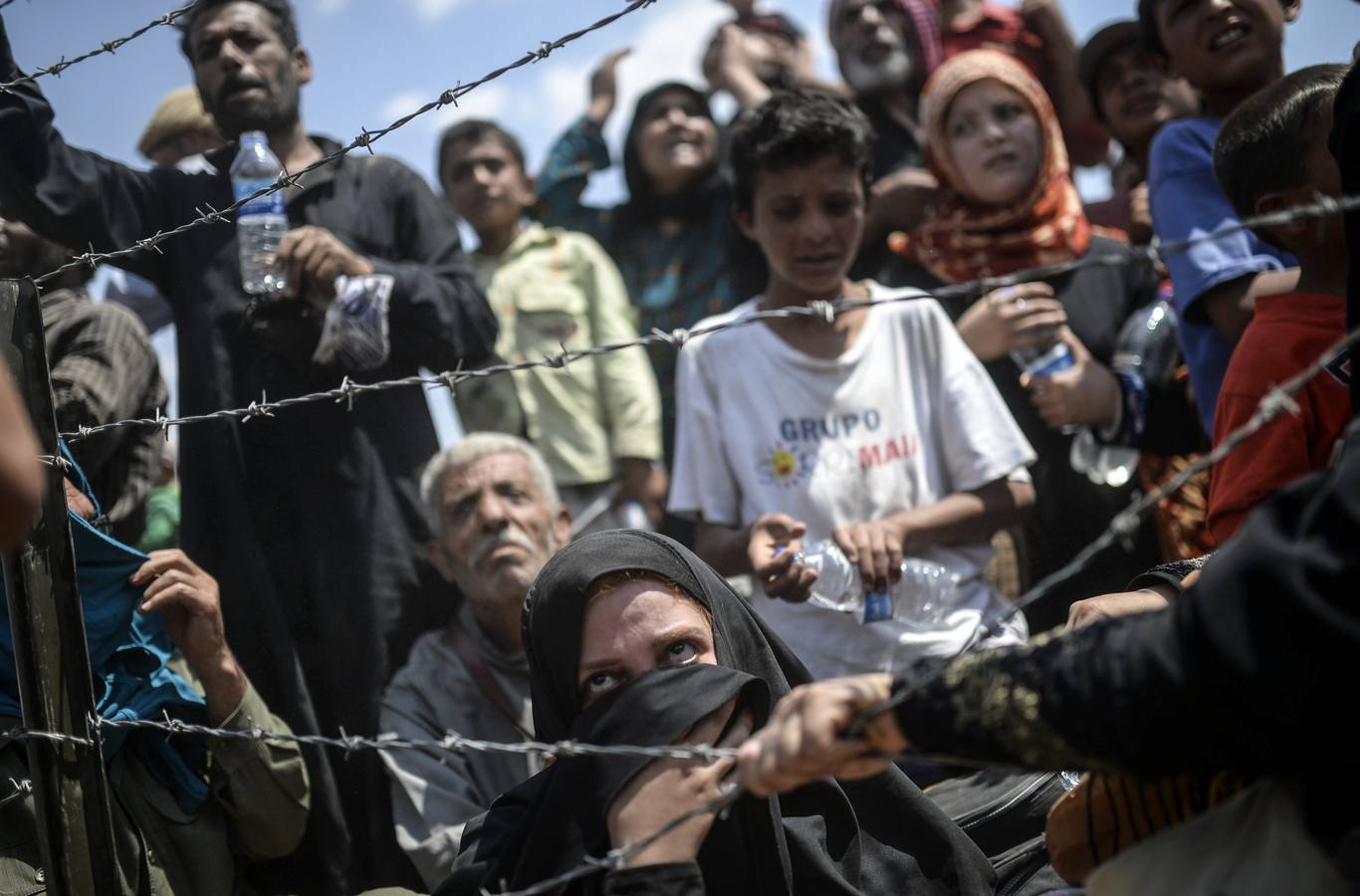 Fotografía de la serie ganadora del tercer premio en "Historias" de la categoría de noticias puntuales de la 59 edición del World Press Photo, tomada por el fotógrafo turco Bulent Kilic. La fotografía muestra a varias familias sirias intentando cruzar ilegalmente la frontera turca cerca de la ciudad de Akçakale (Turquía) el 14 de junio de 2015.