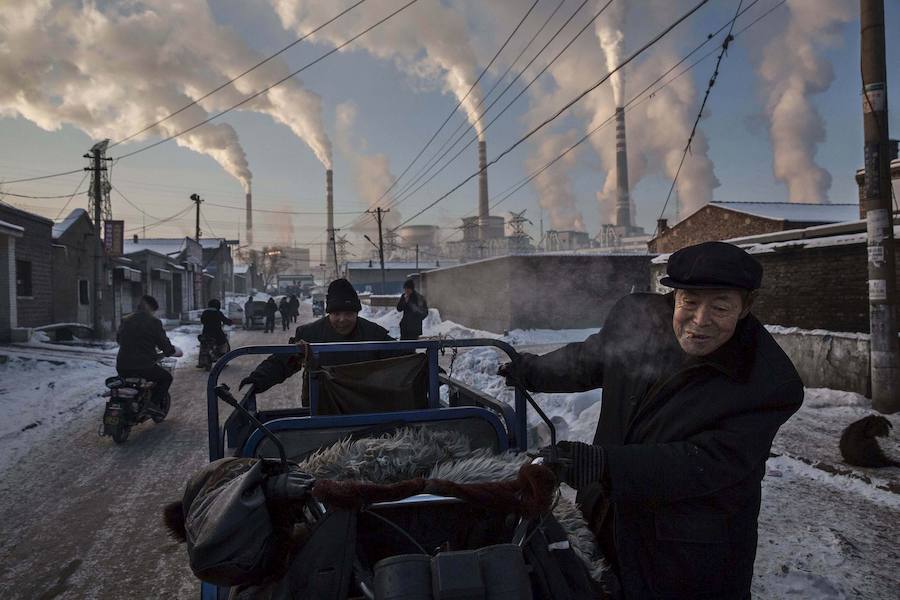 Primer premio en la categoría de Vida Cotidiana. Un ciudadano chino empuja un carro junto a una planta de Carbón en Shanxi.