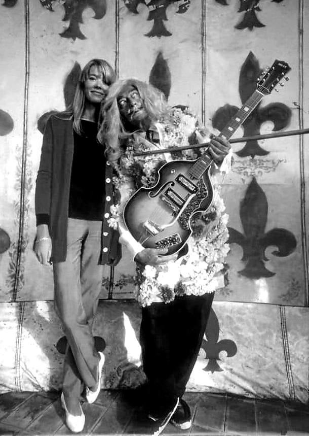 Posando con peluca y guitarra eléctrica junto a la cantante Françoise Hardy