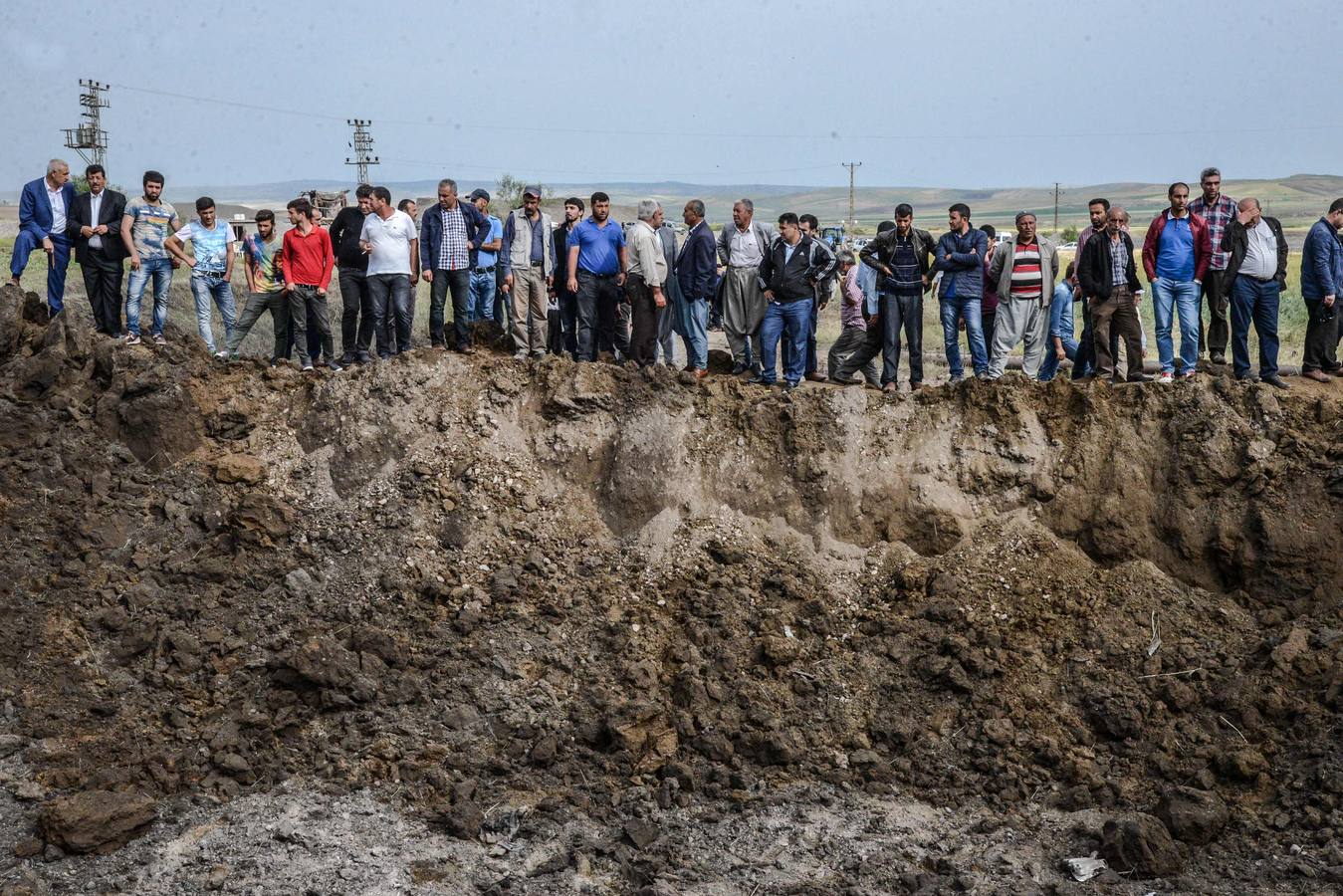 Un grupo de personas junto a un cráter en Sarikamis, zona de mayoría kurda cerca de la ciudad turca de Diyarbakir, donde los bombarderos dejaron 12 muertos.